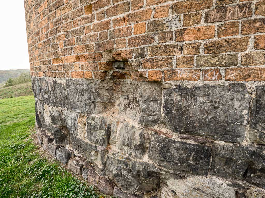 Burg Stolpe Direkt über dem Bodenniveau sind behauener Feldsteine erkennbar, darüber drei Lagen behauener Höör-Sandsteine. In der Bildmitte sieht man eine Kriegsbeschädigung.