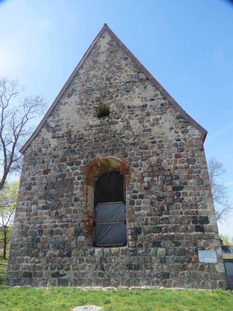 Kirche Dolgelin 2020. Ostfassade mit zwei originalen gedrückt spitzbogigen Fenstern und bis zum Giebel sauber gequadertem Feldsteinmauerwerk