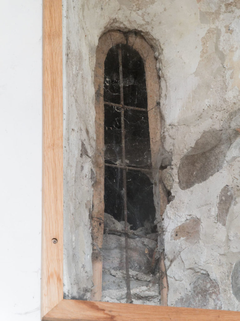 Romanisches Fenster zur Sakristei. Der hölzerne Bogen wurde dendrochronologisch auf die Zeit um 1208 datiert.
